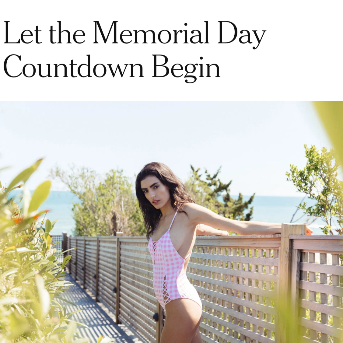 Woman in a pink swimsuit standing by a wooden fence with text 'Let the Memorial Day Countdown Begin' on a scenic background. NYTIMES